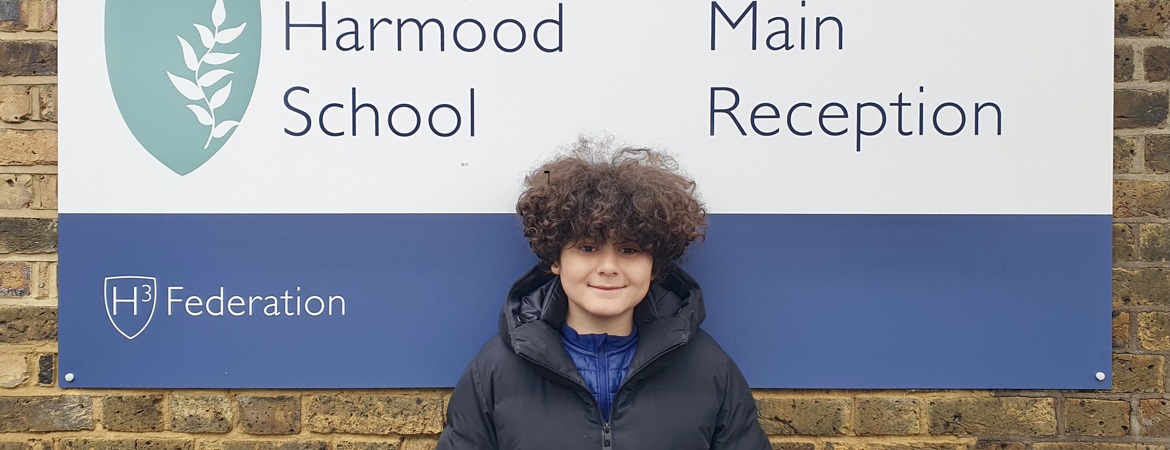 Harmood School Pupil in front of main school signage